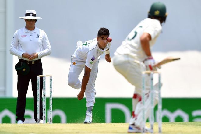 El marcapasos de Pakistán, Naseem Shah (C), se enfrenta al australiano Joe Burns (R) en el segundo día del primer partido de cricket de prueba entre Pakistán y Australia en el Gabba.