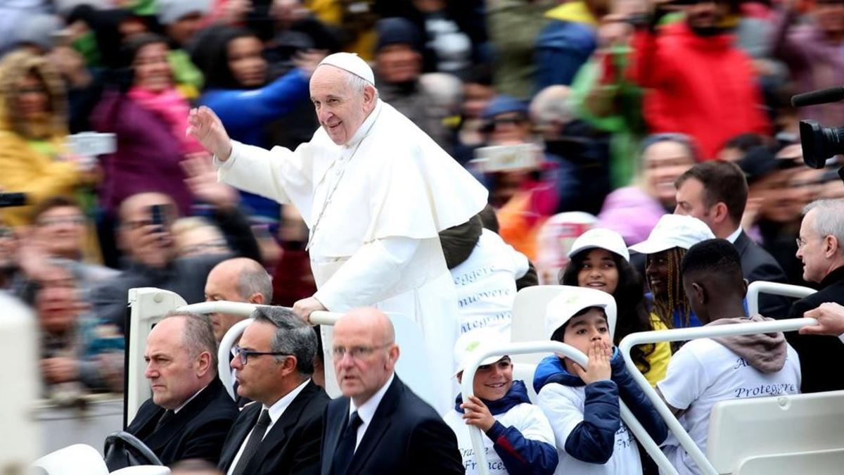 Los niños acompañan al Papa mientras saluda a los fieles a su llegada a a la plaza de San Pedro.