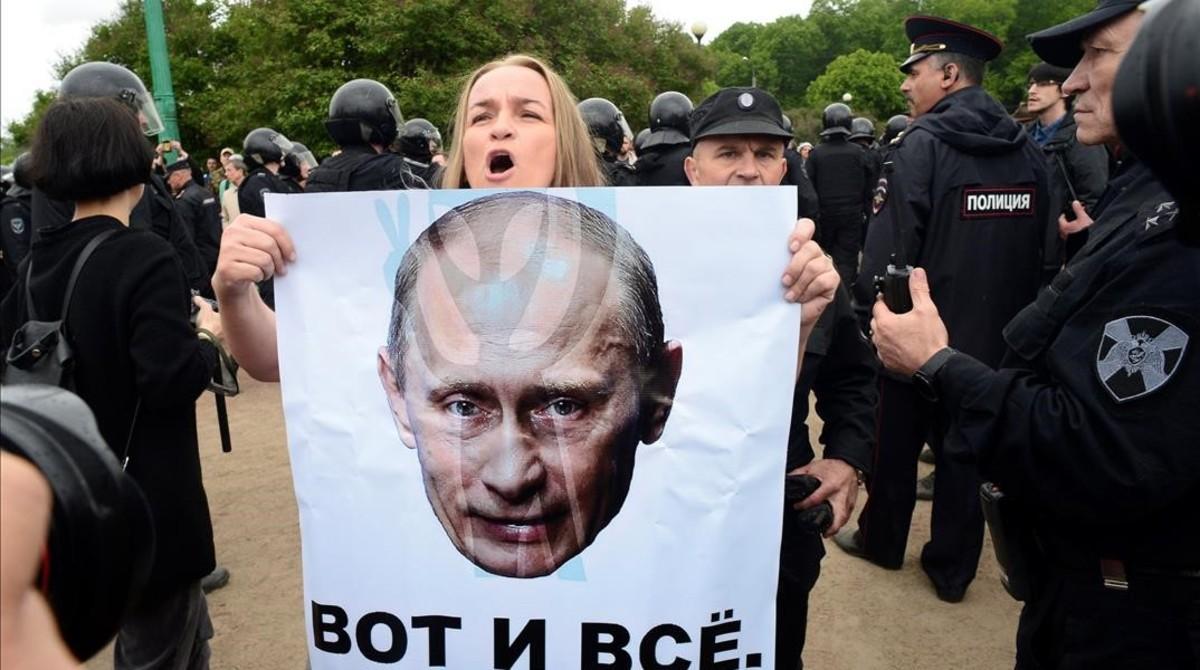 Una manifestante muestra un poster de Putin en San Petesburgo.