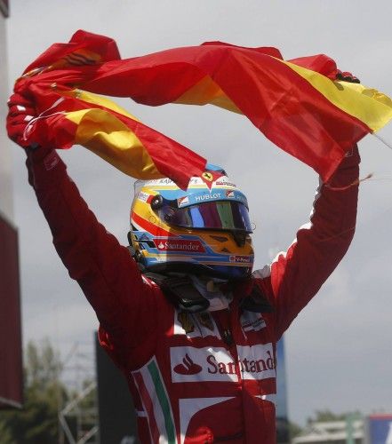 Ferrari Formula One driver Fernando Alonso of Spain holds up his national flag as he celebrates winning the Spanish F1 Grand Prix at the Circuit de Catalunya in Montmelo, near Barcelona