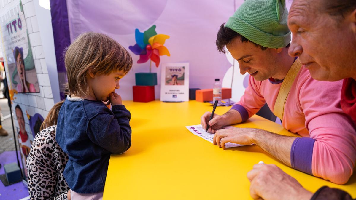 Titó i John C firman libros y láminas a los más pequeños.