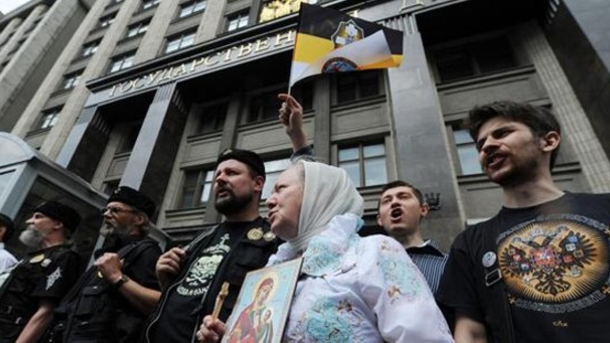 Activistas ortodoxos antigais se manifiestan a favor de la ley en el exterior de la Duma, este martes en Moscú.