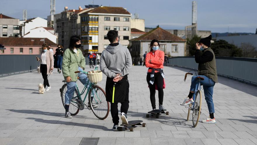 Jóvenes con mascarillas y guardando la distancia de seguridad charlando en Pontevedra.