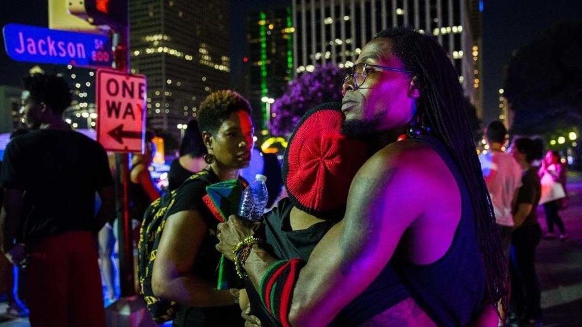 Manifestantes se abrazan tras los disparos durante la protesta en Dallas.