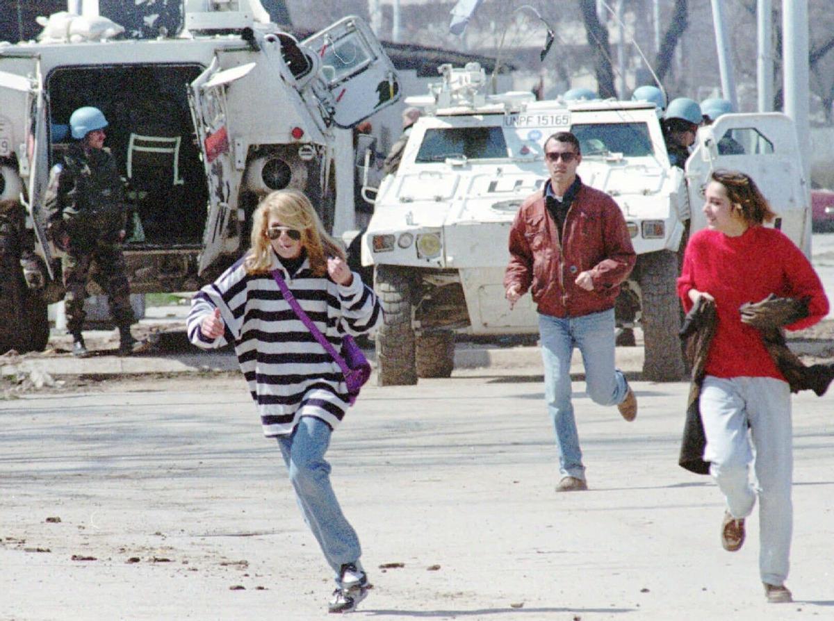 Civiles corren en la conocida como avenida de los francotiradores de Sarajevo, protegidos por un tanque de la ONU, en abril de 1995.