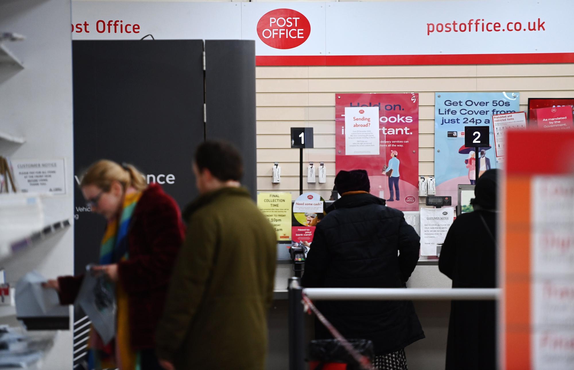 Trabajadores y clientes en una oficina de Post Office, en Londres.