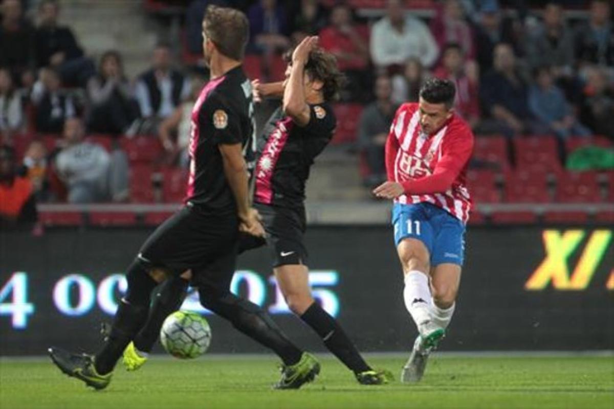 Aday, centrocampista del Girona, prueba el disparo ante dos jugadores del Almería, ayer en Montilivi.