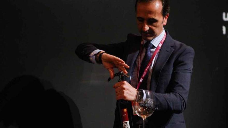 El diputado de Turismo, José Luis Prieto, descorcha una botella de vino en Fitur.