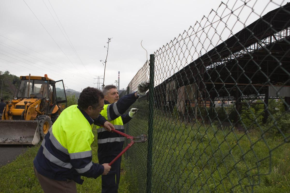 Operarios del Ayuntamiento de Langreo cortando el cierre de Talleres del Conde en 2011