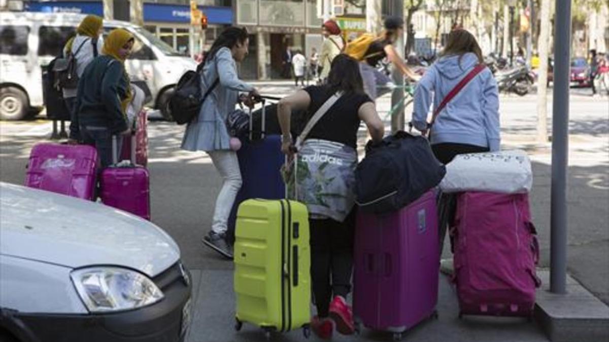 Hacia el piso 8 Tres turistas con sus maletas cruzan la Gran Via, ayer.