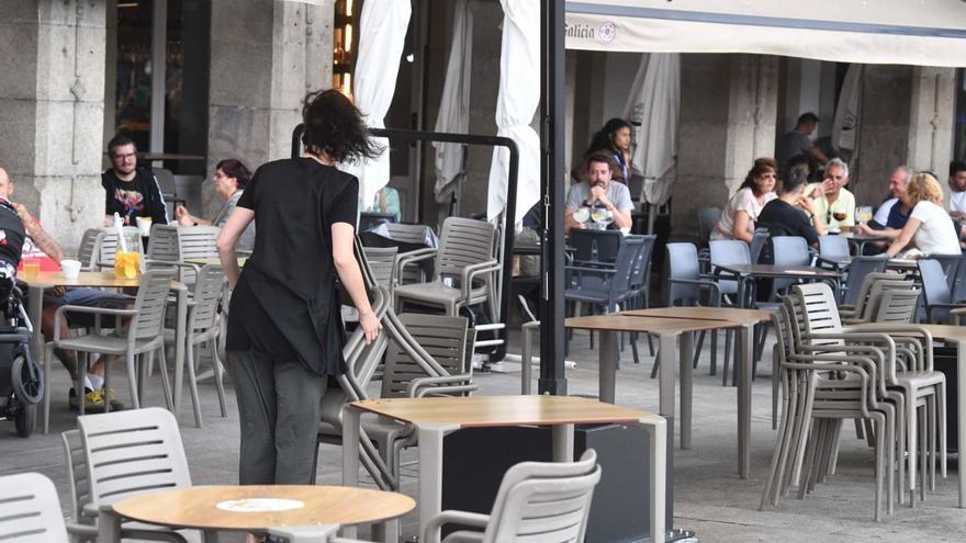 Una camarera instala una terraza de hostelería en el centro de la ciudad. |   // VÍCTOR ECHAVE