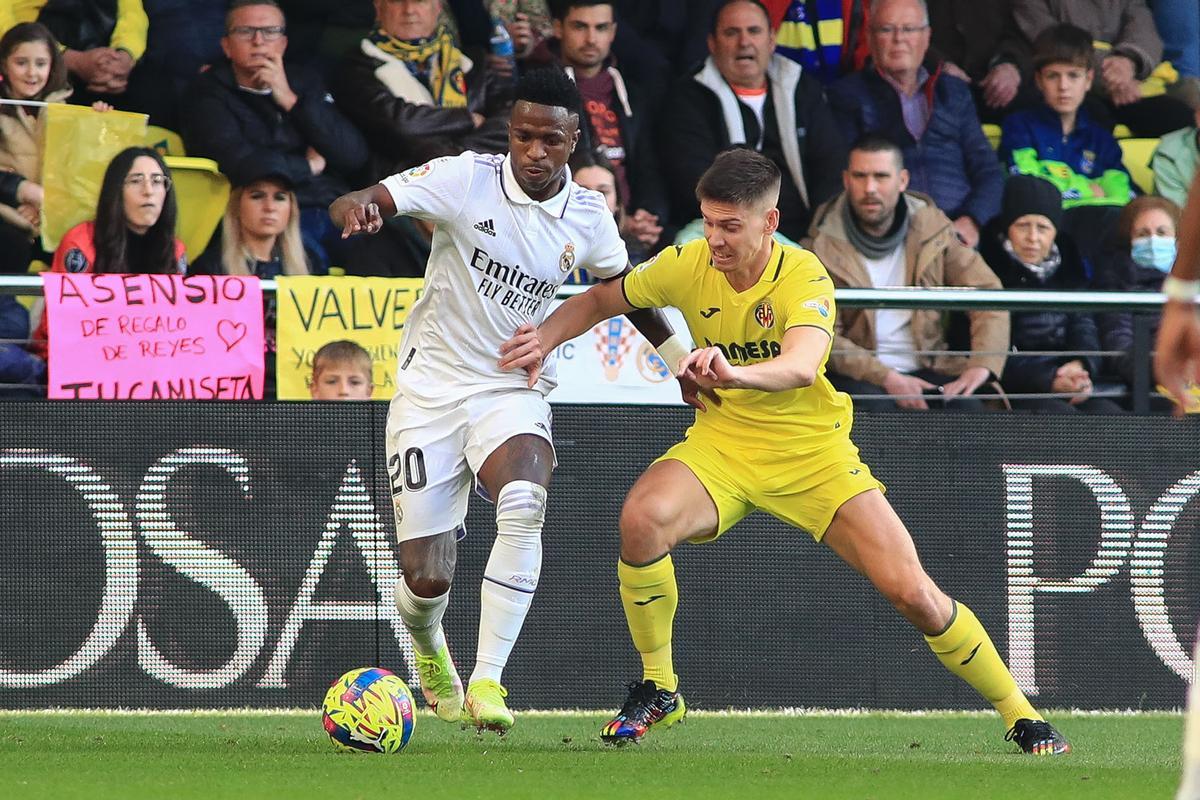 VILLARREAL, 07/01/2023.-El delantero del Real Madrid Vinicius Jr (i) con el balón ate Juan Foyth, del Villarreal durante el partido de la jornada 16 de LaLiga Santander que el Villarreal y el Real Madrid disputan este sábado en el estadio de La Cerámica en Villarreal.- EFE / Domenech Castelló