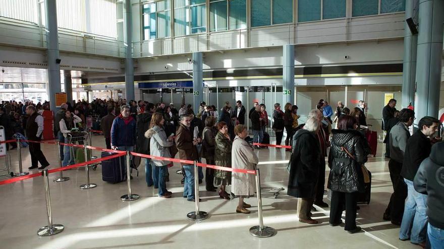 Un grupo de pasajeros damnificados por el caos aéreo hacen cola en el aeropuerto de Asturias para presentar sus reclamaciones, el 4 de diciembre de 2010.