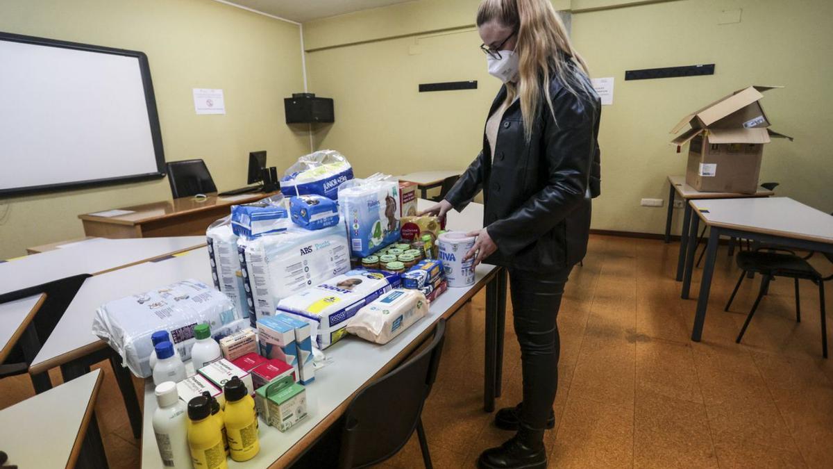 Una voluntaria clasificando material sanitario en la Facultad de Economía y Empresa de Oviedo.