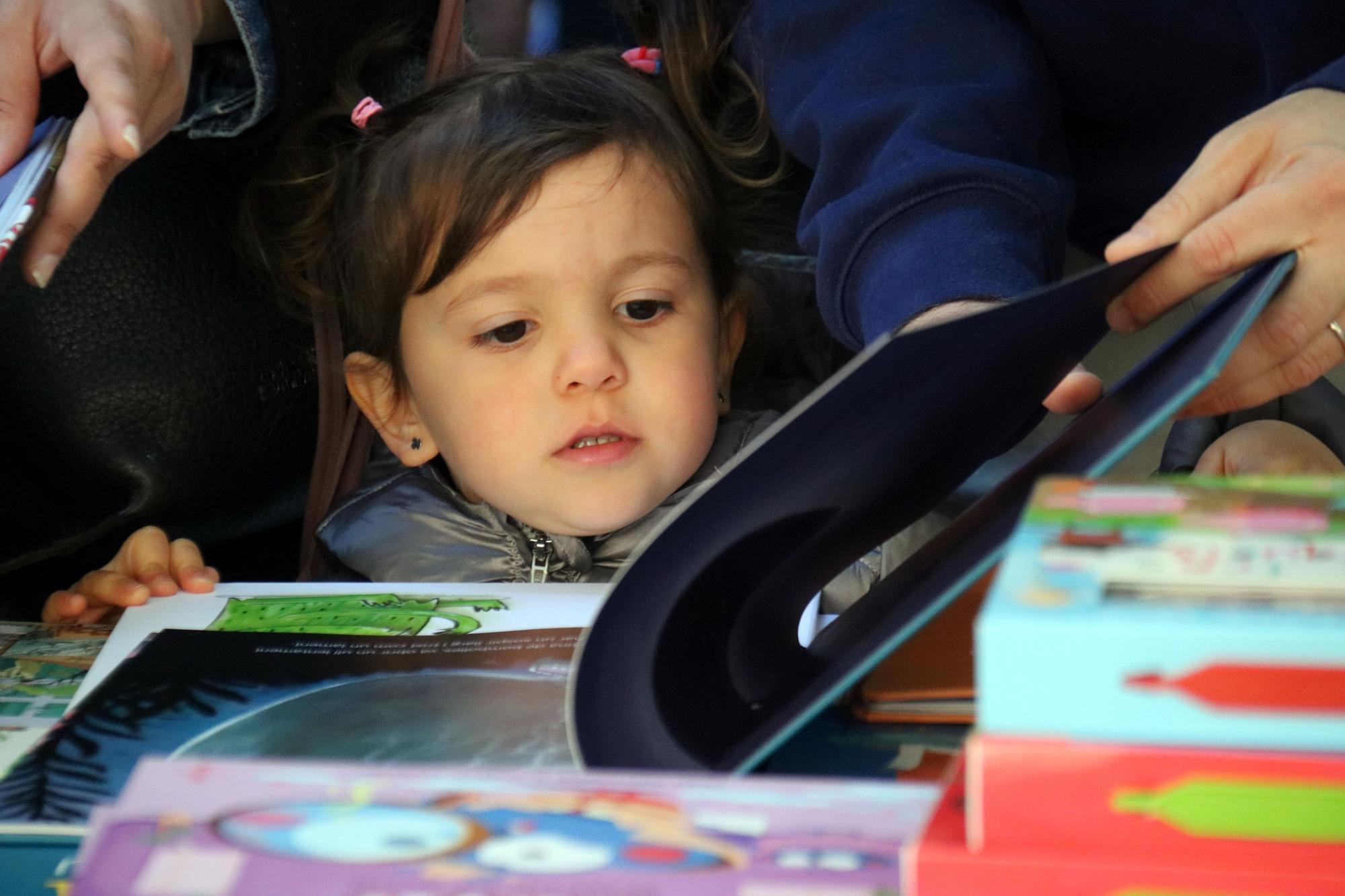 Una nena mirant un llibre a Manresa