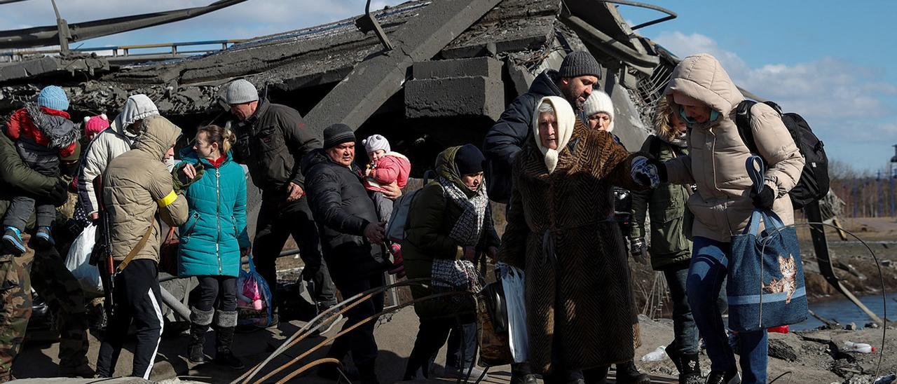 Vecinos de Irpin, a las afueras de Kiev, huyen de su ciudad a través de un puente destruido