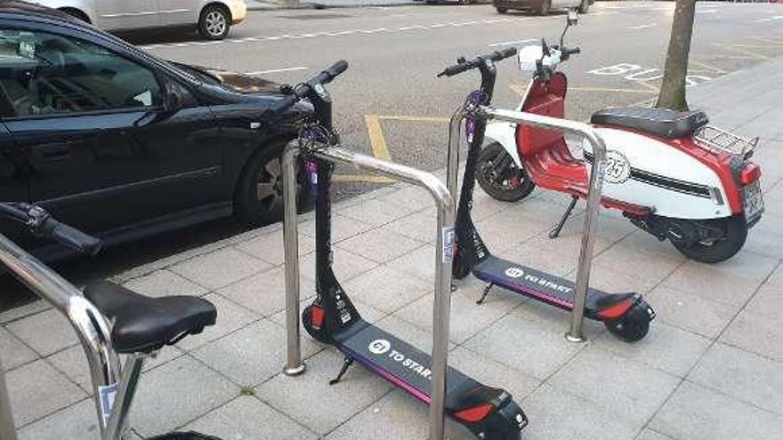 Patinetes de alquiler en un aparcabicis de Oviedo.