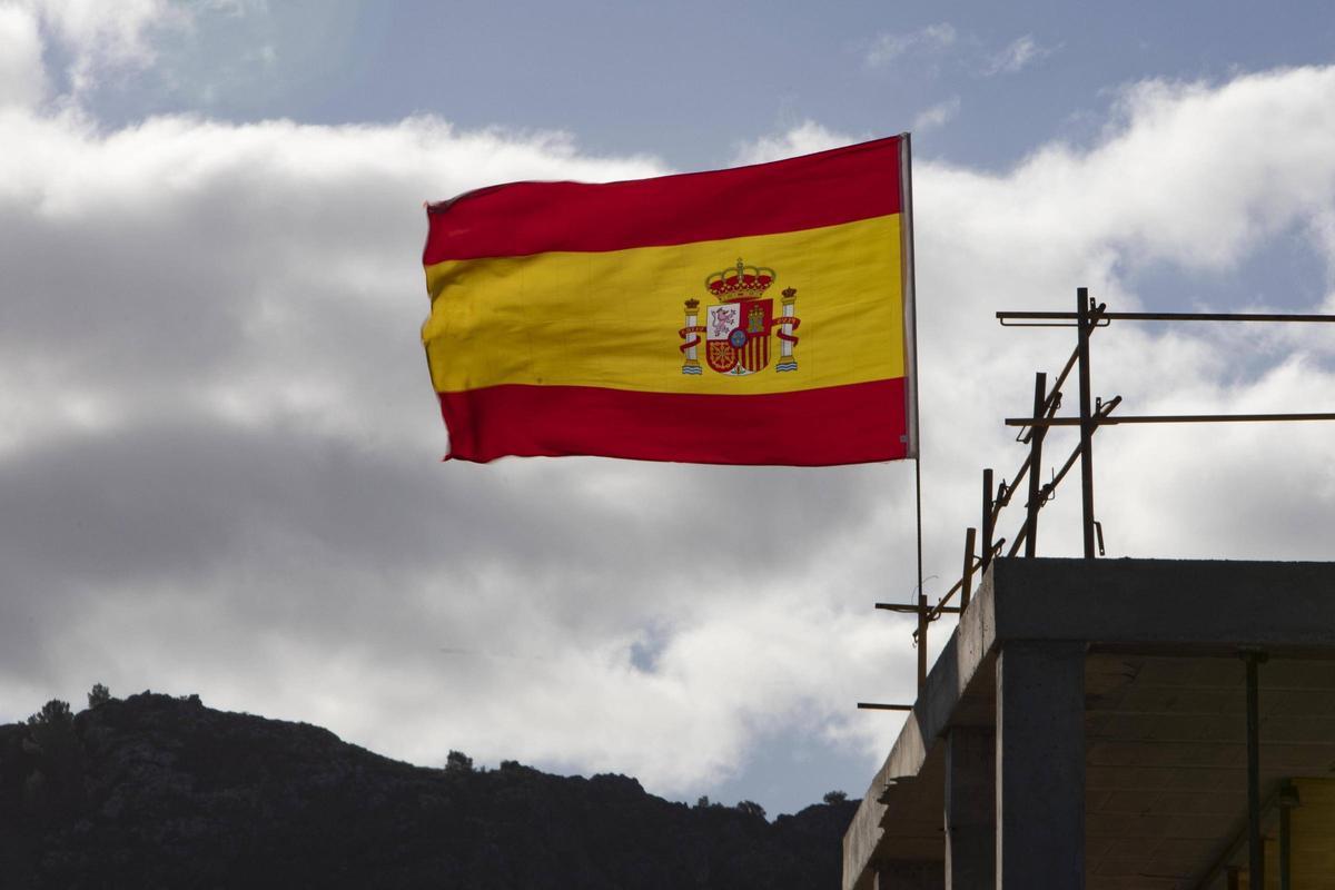 Bandera de España ondenado al viento en una obra en Xàtiva