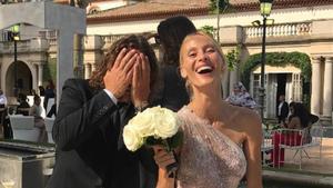 Carles Puyol bromea con su pareja, Vanesa Lorenzo, que posa con el ramo de novia de Yolanda Cardona.   