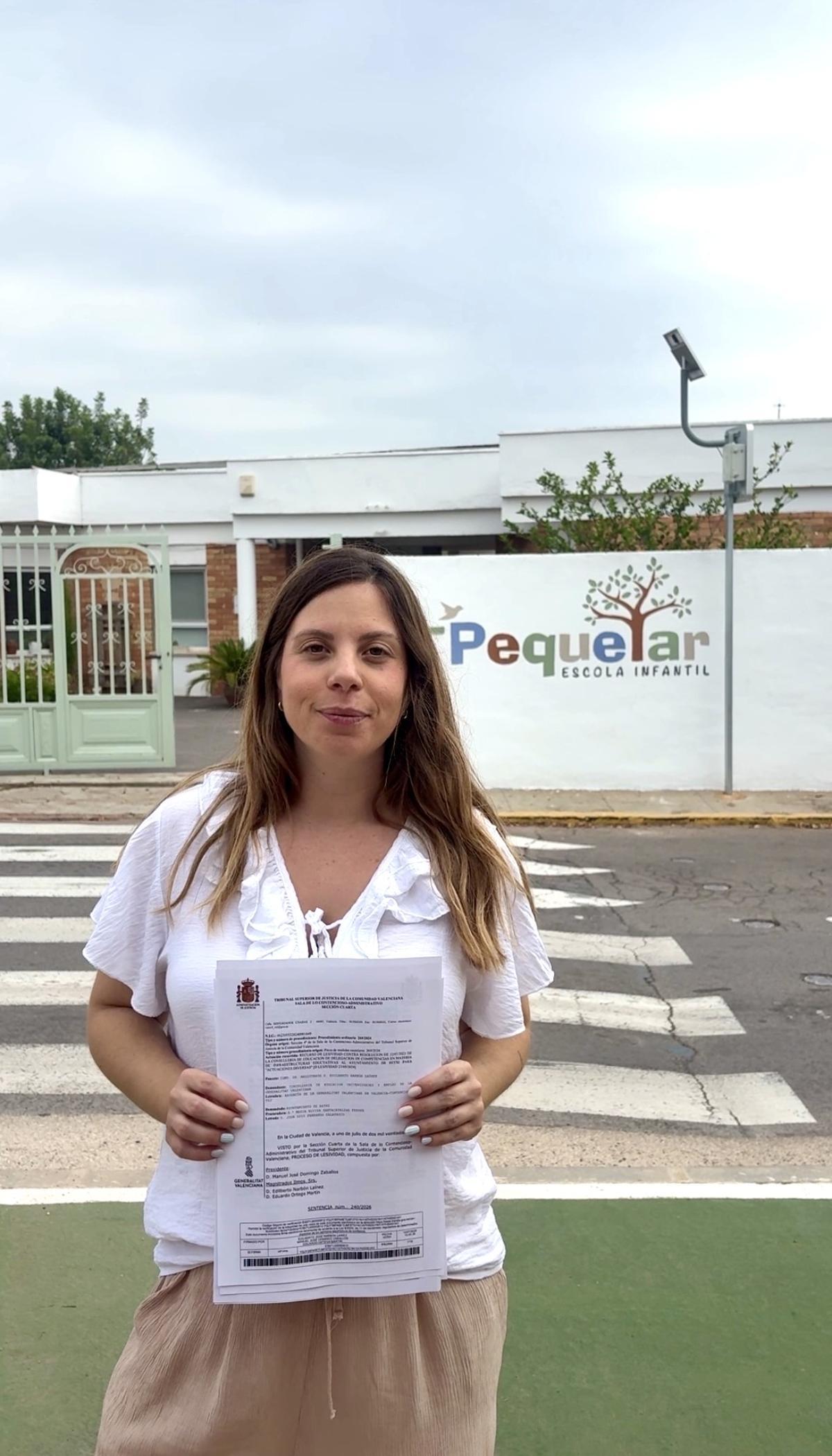 La alcaldesa, Carla Nebot, con la sentencia, delante de la escuela infantil.