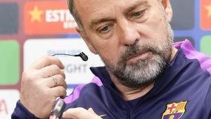 Hansi Flick se quita el auricular en la sala de prensa de la ciudad deportiva.