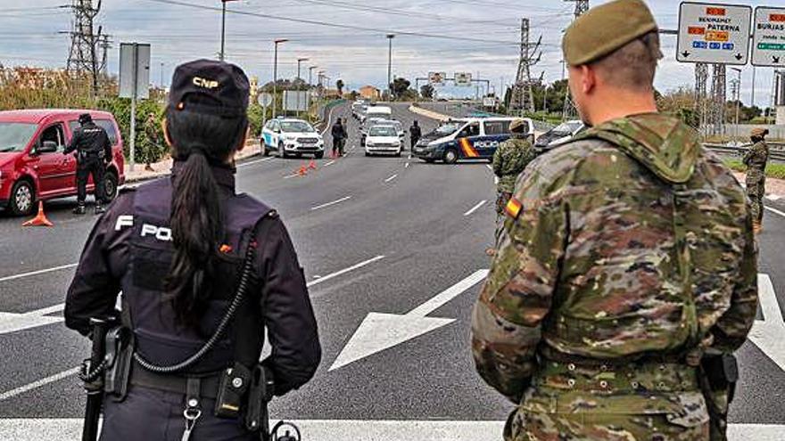 Agentes de policía y militares vigilan una carretera de Valencia para controlar que se cumplen las medidas de confinamiento.