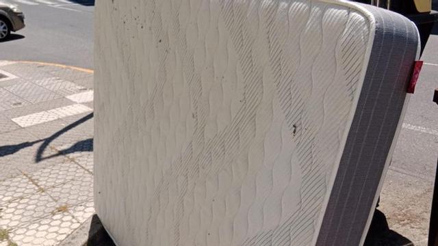 Distintos tipos de materiales tirados al lado de contenedores.