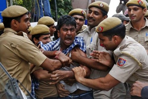 Police detain a supporter of Chandrababu Naidu, chief of Telugu Desam Party, as he tries to stop a vehicle from carrying Naidu to a hospital in New Delhi