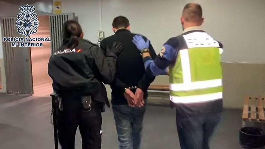 El detenido es trasladado por dos agentes de la Policía Nacional.