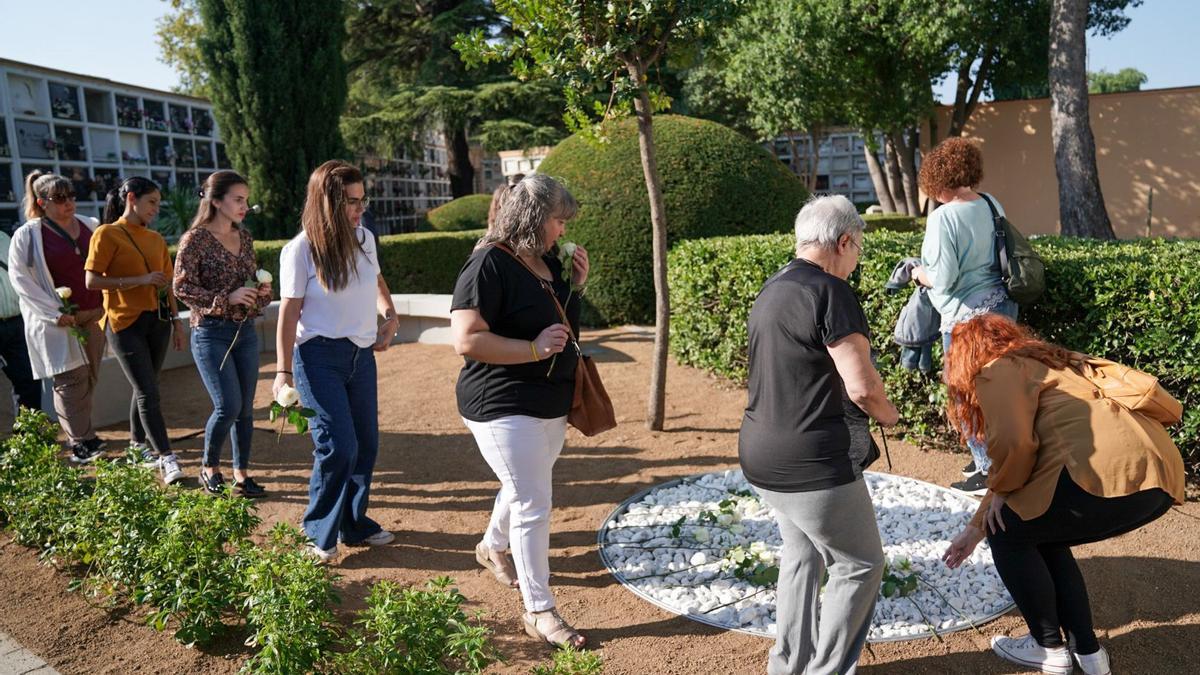 Assistents a l&#039;acte dipositant roses blanques a l&#039;espai