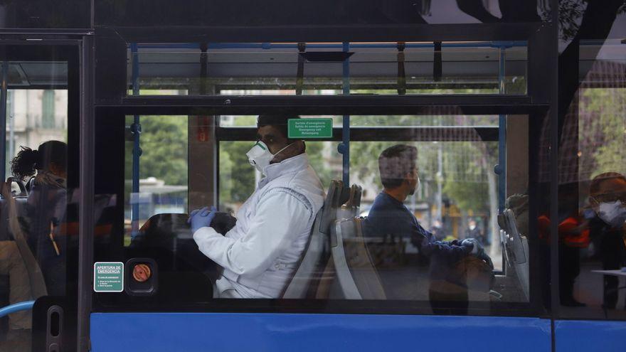 Un hombre con mascarilla en un autobús.