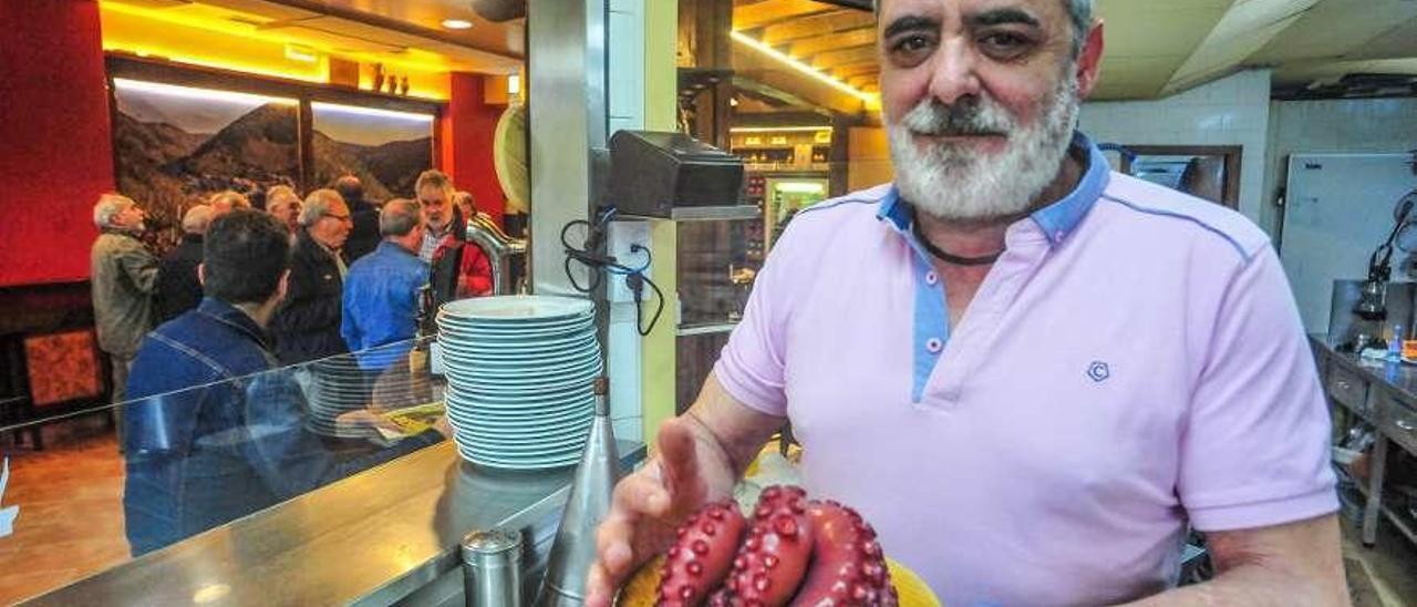 El hostelero Óscar Caseiro muestra un pulpo, producto estrella en su establecimiento. // Iñaki Abella