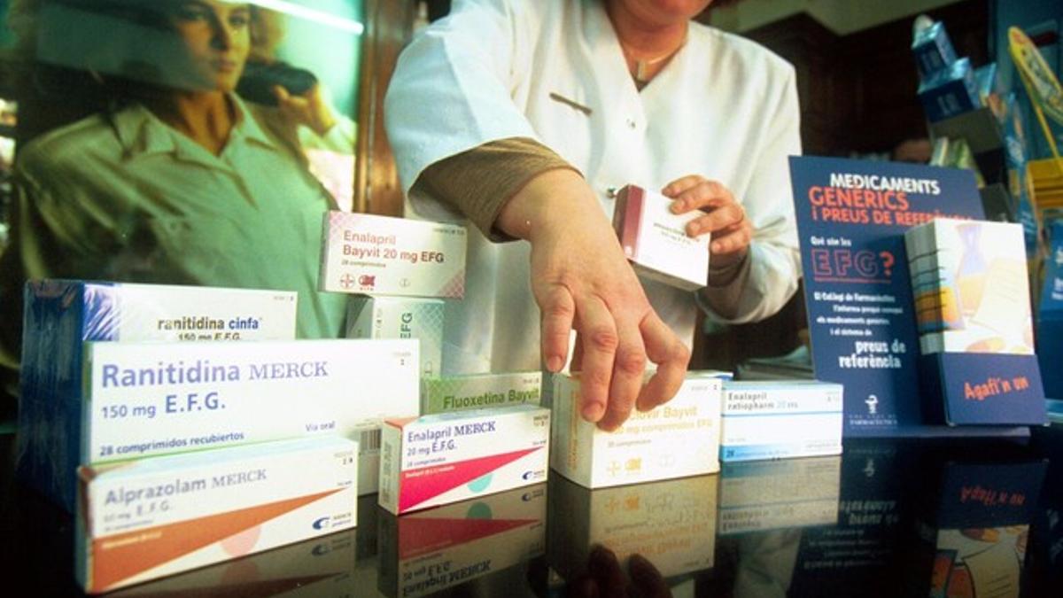 Una farmacéutica muestra medicamentos genéricos.