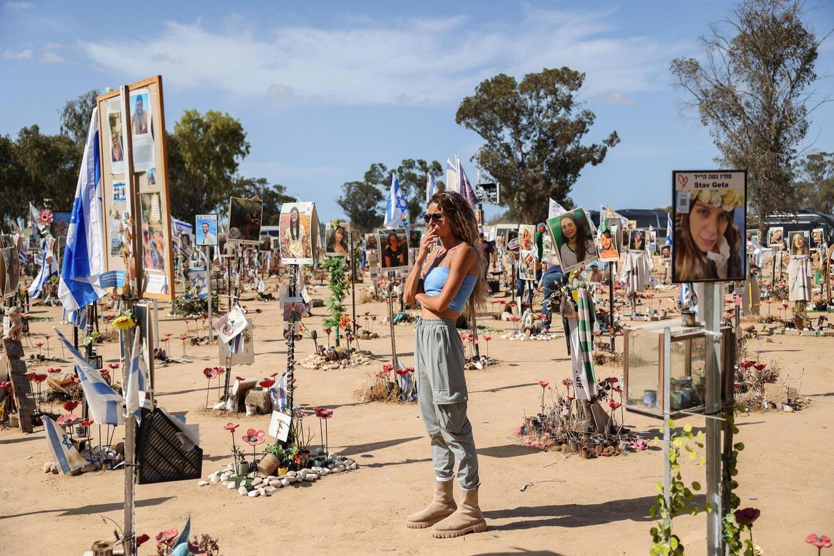 Una joven observa las fotografías de víctimas de Hamás en el festival Supernova, cerca del kibutz Reim, en el sur de Israel, durante el 7 de octubre de 2023.