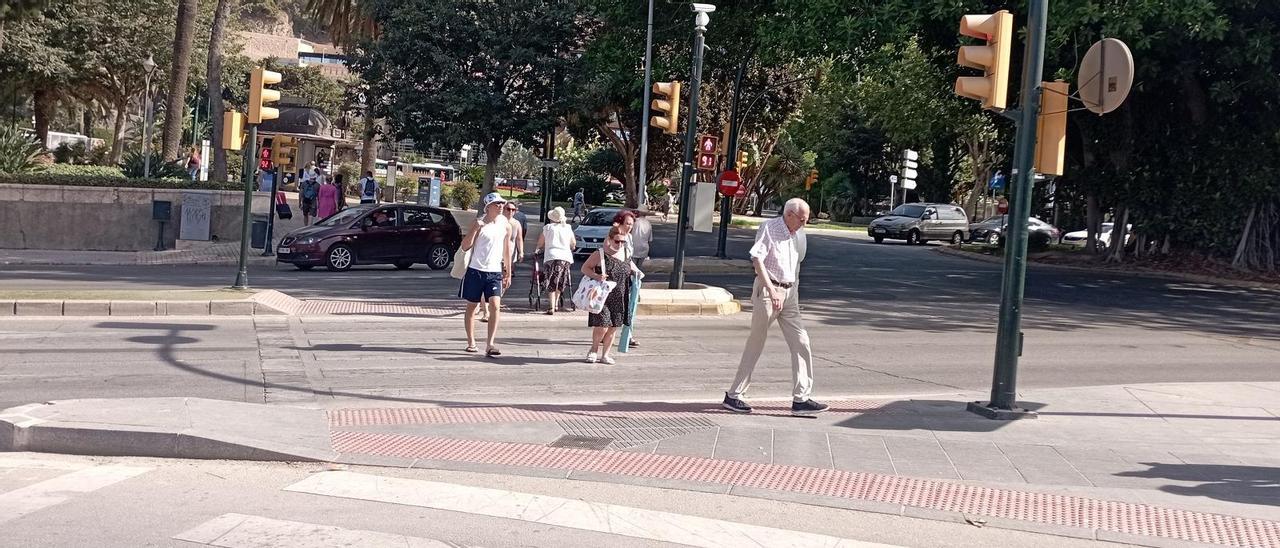 Peatones cruzan por los pasos de cebra de los 21 segundos, en el momento en que los semáforos se ponen en rojo.