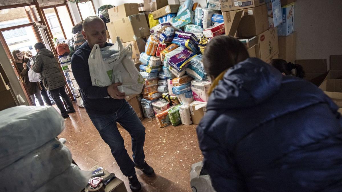 Membres de l’associació Ucraïna al Cor endreçant el material solidari  per enviar a Ucraïna, ahir al migdia | OSCAR BAYONA