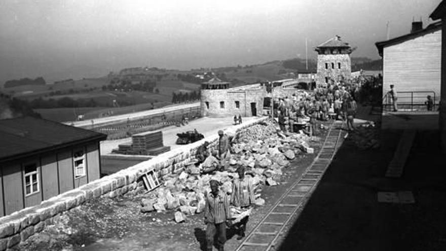 Prisioneros trabajando en el levantamiento de un muro. En primer plano, dos presos «rojos españoles».