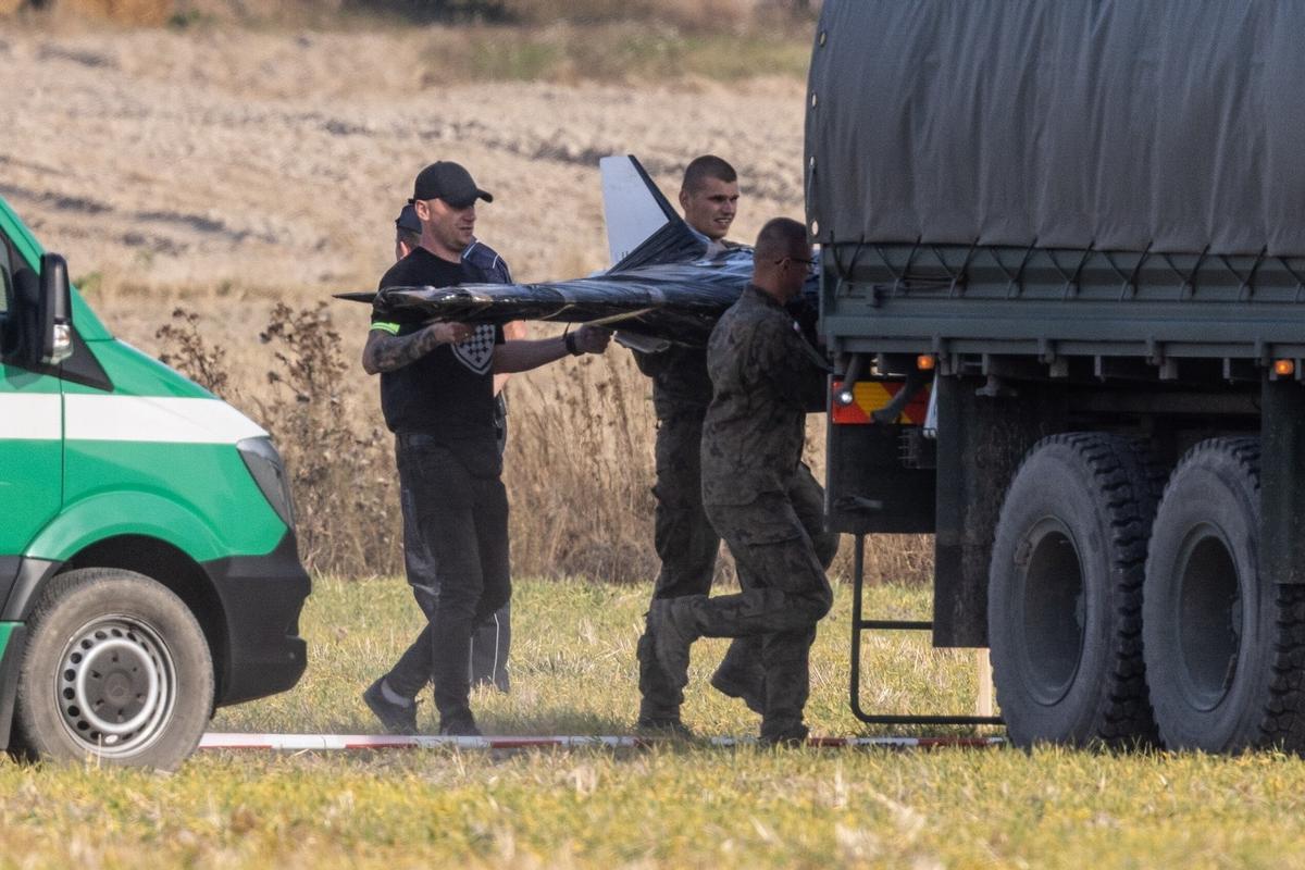 Miembros de las Fuerzas de la Defensa Territorial Nacional recogen los restos de un dron que invadió desde Bielorrusoa el espacio aéreo polaco.