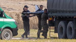 Miembros de las Fuerzas de la Defensa Territorial Nacional recogen los restos de un dron que invadió desde Bielorrusoa el espacio aéreo polaco.