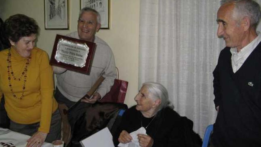 Vicenta Prieto junto a varios de sus familiares toma un vaso de chocolate y recibe una placa conmemorativa.