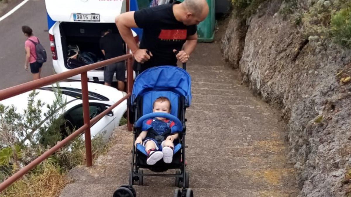 Un padre sortea los escalones para poder salir con su bebé de su casa.