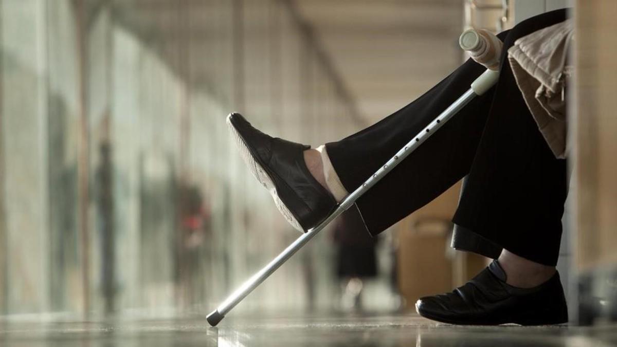 Imagen de archivo de una persona con muleta en la sala de espera de un hospital.
