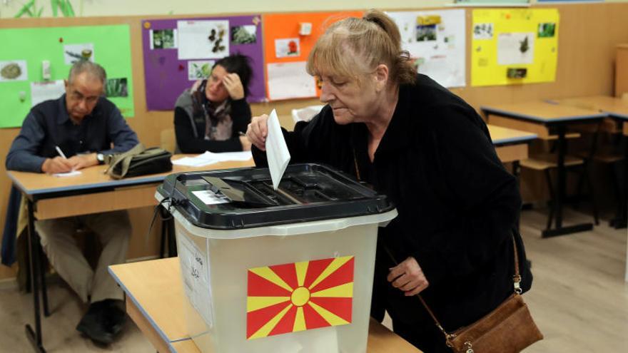 Una mujer introduce su voto en el referéndum de Macedonia.