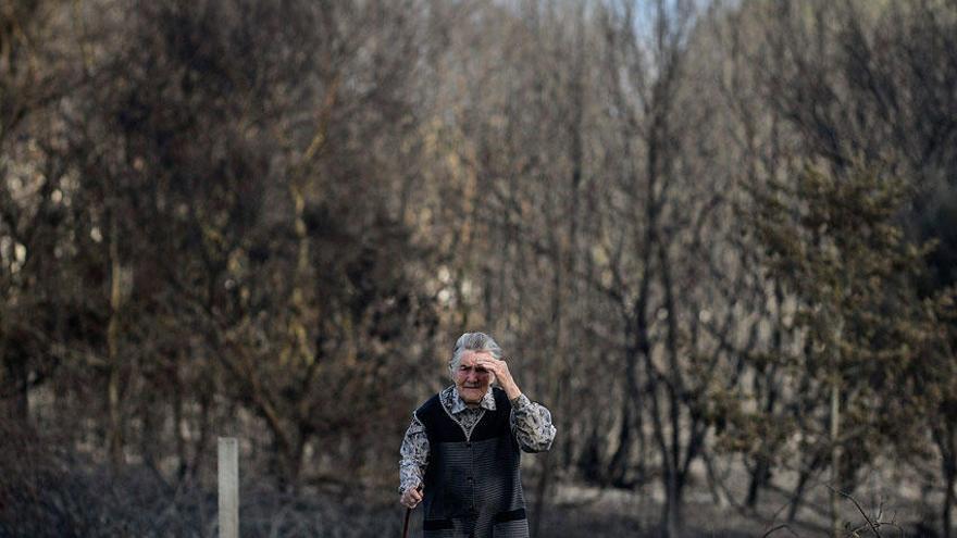 Una mujer en una zona afectada por el incendio de Cualedro.