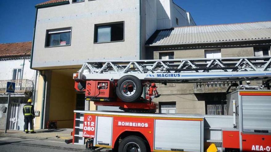 Los bomberos ante el inmueble afectado por las llamas. // Santos Álvarez