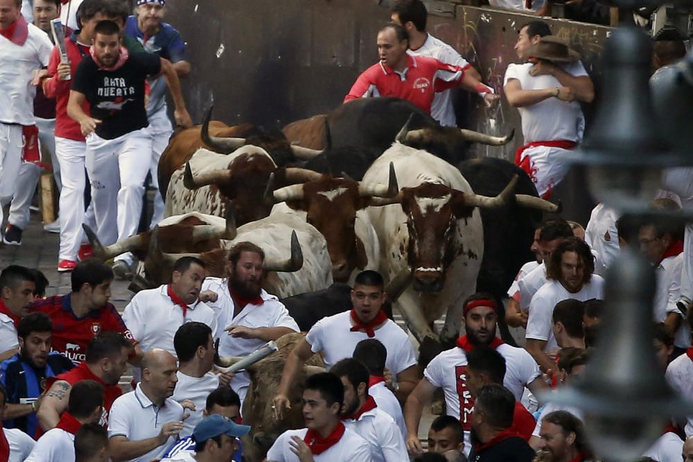 Una manada de toros de la ganadería de Fuente Ymbro, que se ha ido estirando en el recorrido hasta romperse en la calle Estafeta, ha creado emoción en el primer encierro de los Sanfermines de 2016.