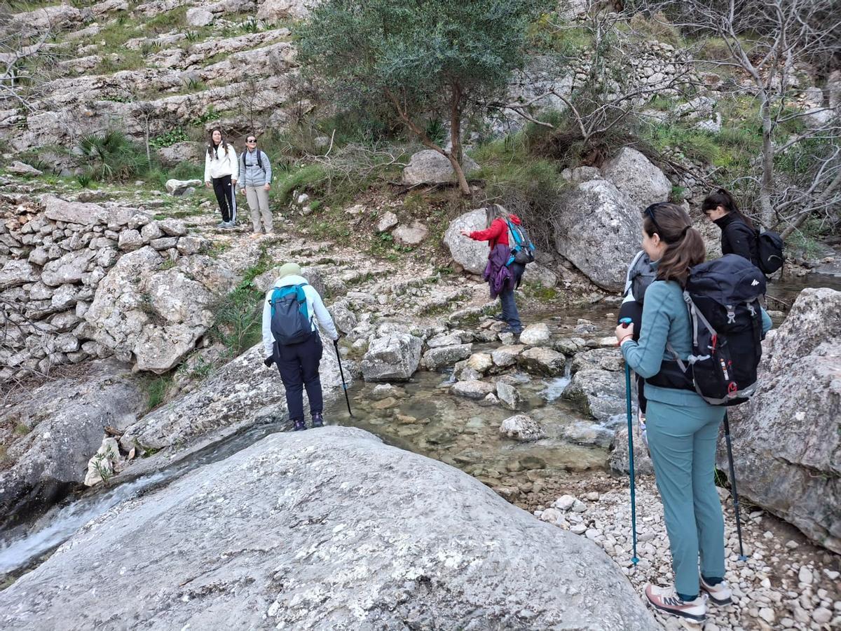 Los excursionistas vadean el riachuelo