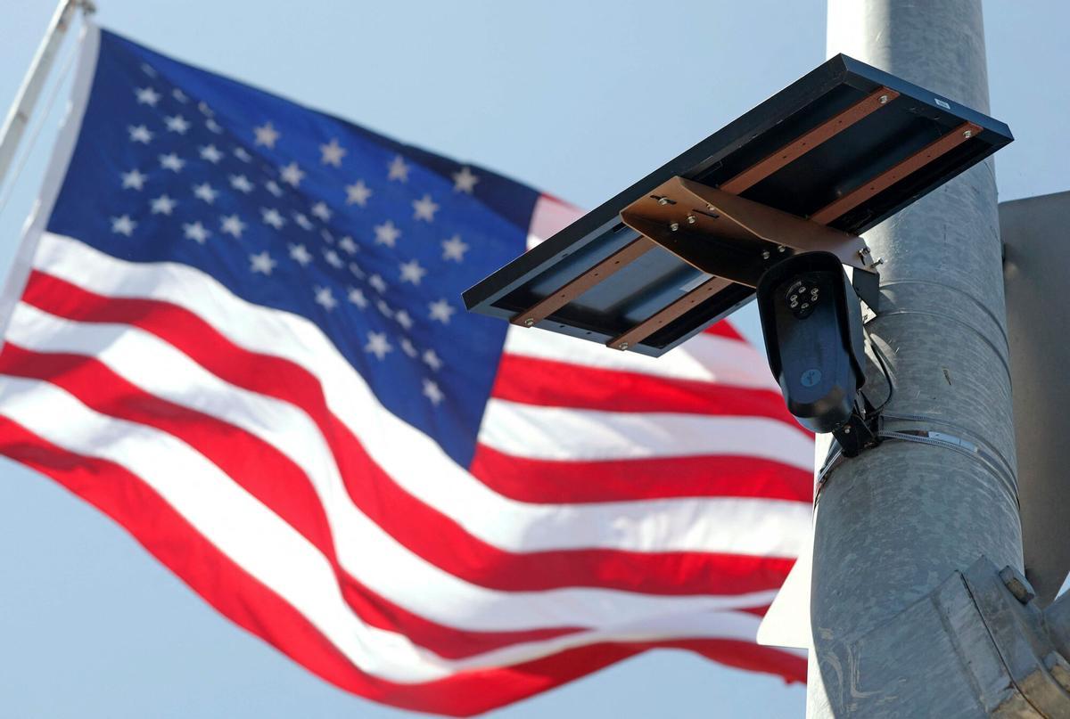 Una bandera de EEUU ondea tras una cámara de la compañía Flock en una calle de Burbank, California.