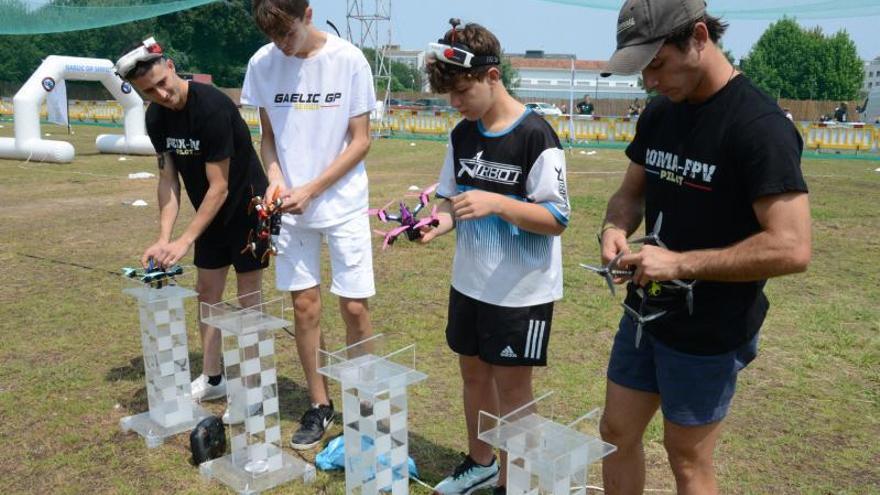 Un grupo de pilotos prepara sus drones para despegar.  