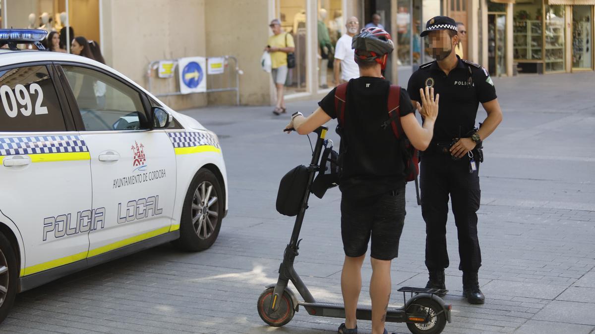 Un policía local en un control a un conductor de patinete en el centro de Córdoba.